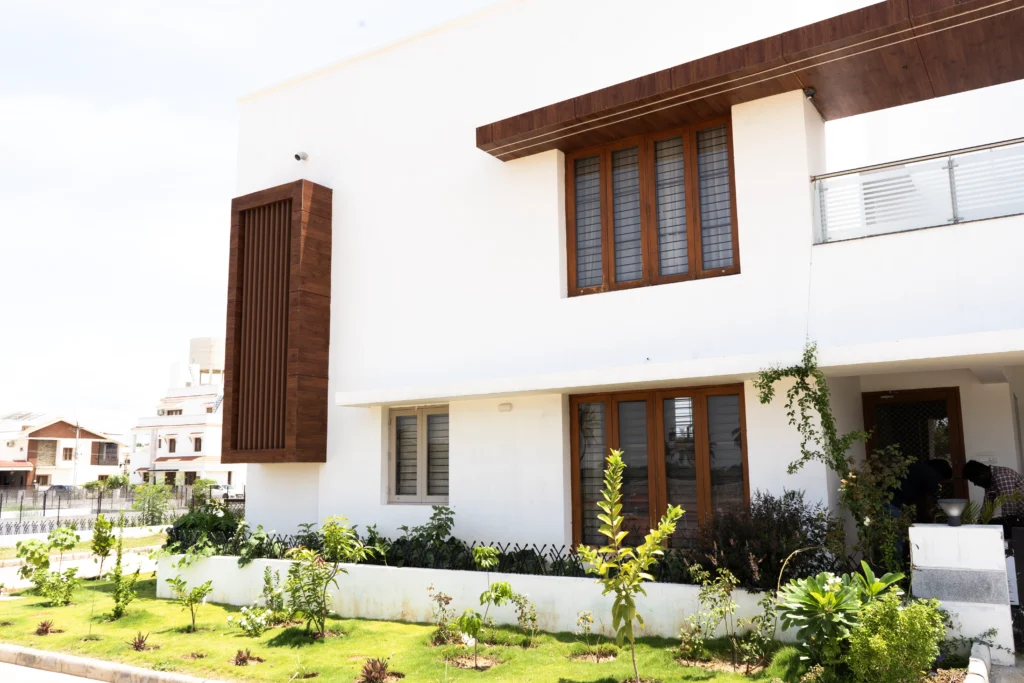 Contemporary house elevation with glass balcony, textured walls, and premium exterior finishes.