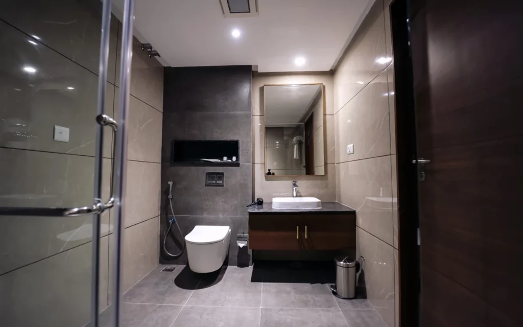 Modern bathroom interior with vanity unit, premium wall tiles, shower enclosure, and stylish lighting.