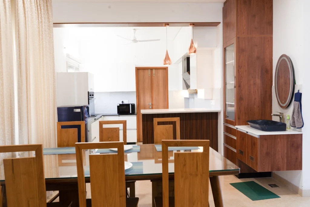 Modern dining room interior with premium dining table, pendant lighting, and decorative wall finishes.