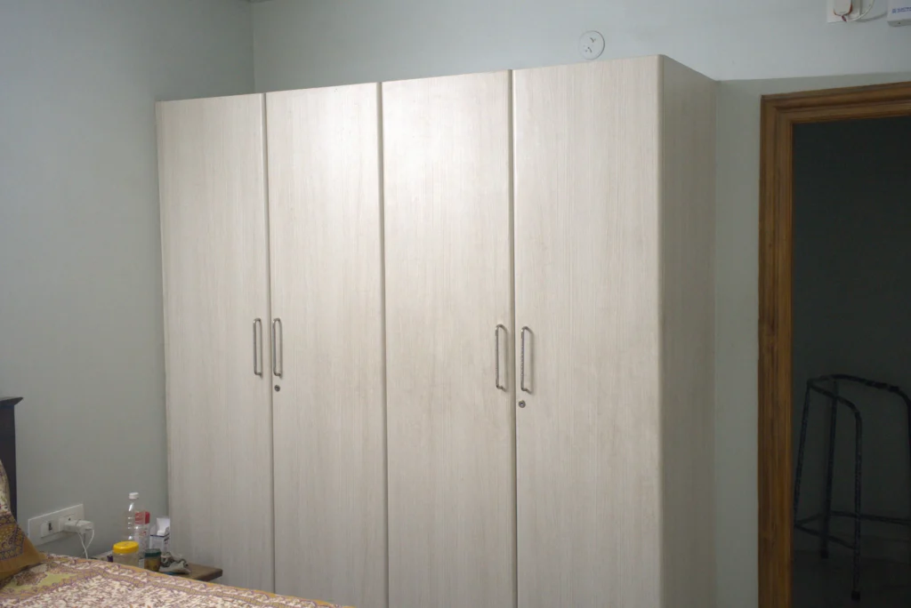 Sliding wardrobe design with mirrored shutters and modular storage for bedroom interiors.
